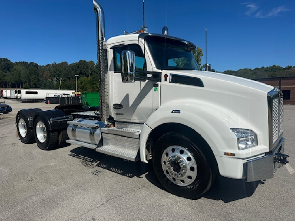 Kenworth T880 Conventional Daycab truck showing front and side view, white exterior, dual rear axles, chrome exhaust stacks, and fuel tanks.