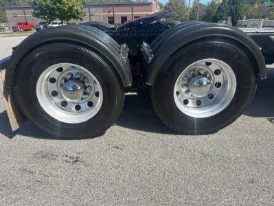 Kenworth T880 dual rear wheels showing aluminum rims and dual tires, part of a Daycab tractor chassis bay.