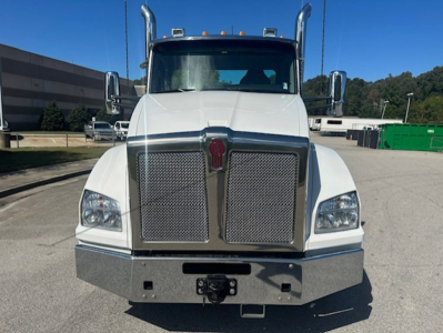 Kenworth T880 front view showing large chrome grille, dual air intakes, square headlights, and heavy-duty bumper. License plate area and hitch visible.