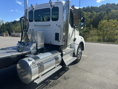Kenworth T880 daytime cab with side steps and fuel tanks; visible are circular aluminum fuel tanks, chrome exhaust stacks, steps, and cab door. No legible text readable on components.