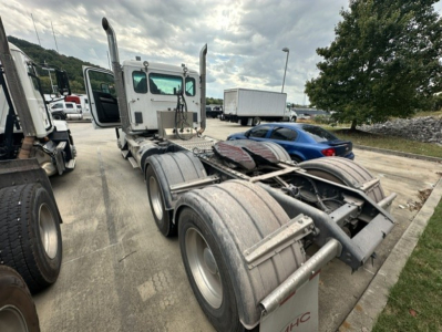 Kenworth T880 truck tractor chassis with sleeper cab, dual rear axles, fifth wheel, and exhaust stacks visible.