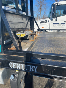 Freightliner M2 106 tow truck bed area showing Century Equipment branding and wheel setup.