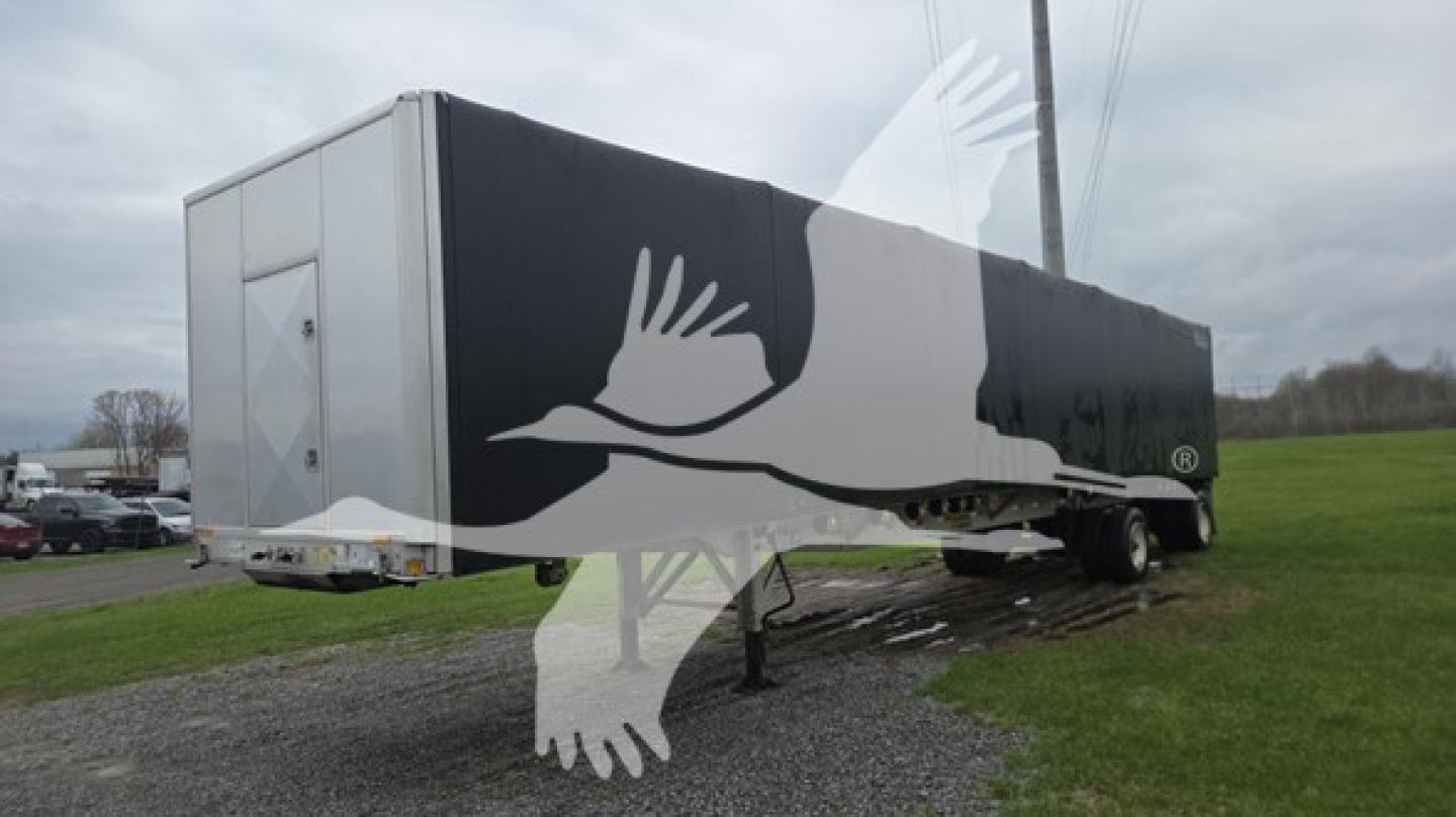 Trailer showing white and black R-logo curtainside with rear door and landing gear, Conestoga style cover on a raised flatbed.