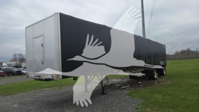 Trailer showing white and black R-logo curtainside with rear door and landing gear, Conestoga style cover on a raised flatbed.