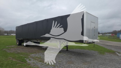 Curtainside trailer with black covered cargo area; front neck and kingpin visible; long rectangular trailer with rear door panel. Overlayed watermark of birds in flight across image.