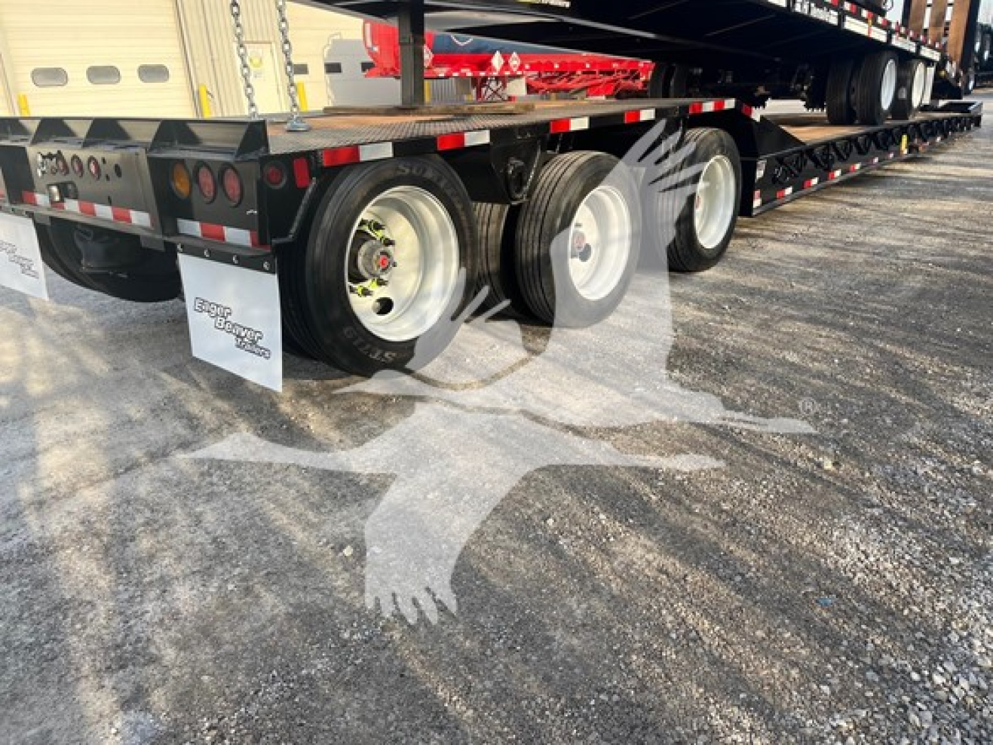 Trailer rear view showing dual rear axles and mudflaps on a lowboy trailer under construction.