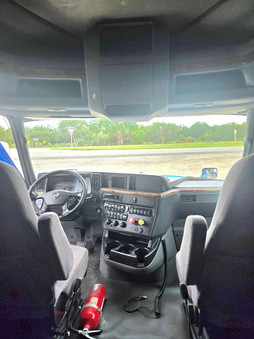Interior cab view of a 2021 International LT625 truck showing dashboard controls, steering wheel, and front seats.