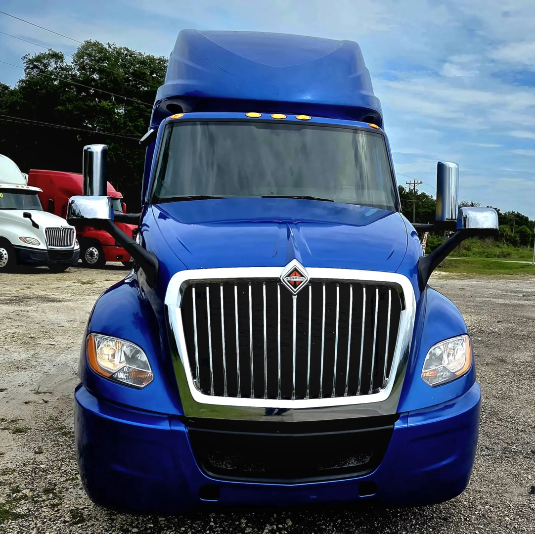 Front view of a blue 2021 International LT625 conventional sleeper truck showing chrome grille, headlights, and large cab with blue color.