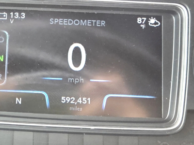 Instrument cluster showing speedometer at 0 mph, odometer reading 592,451 miles, outside temp 87°F, and 13.3V indicator.