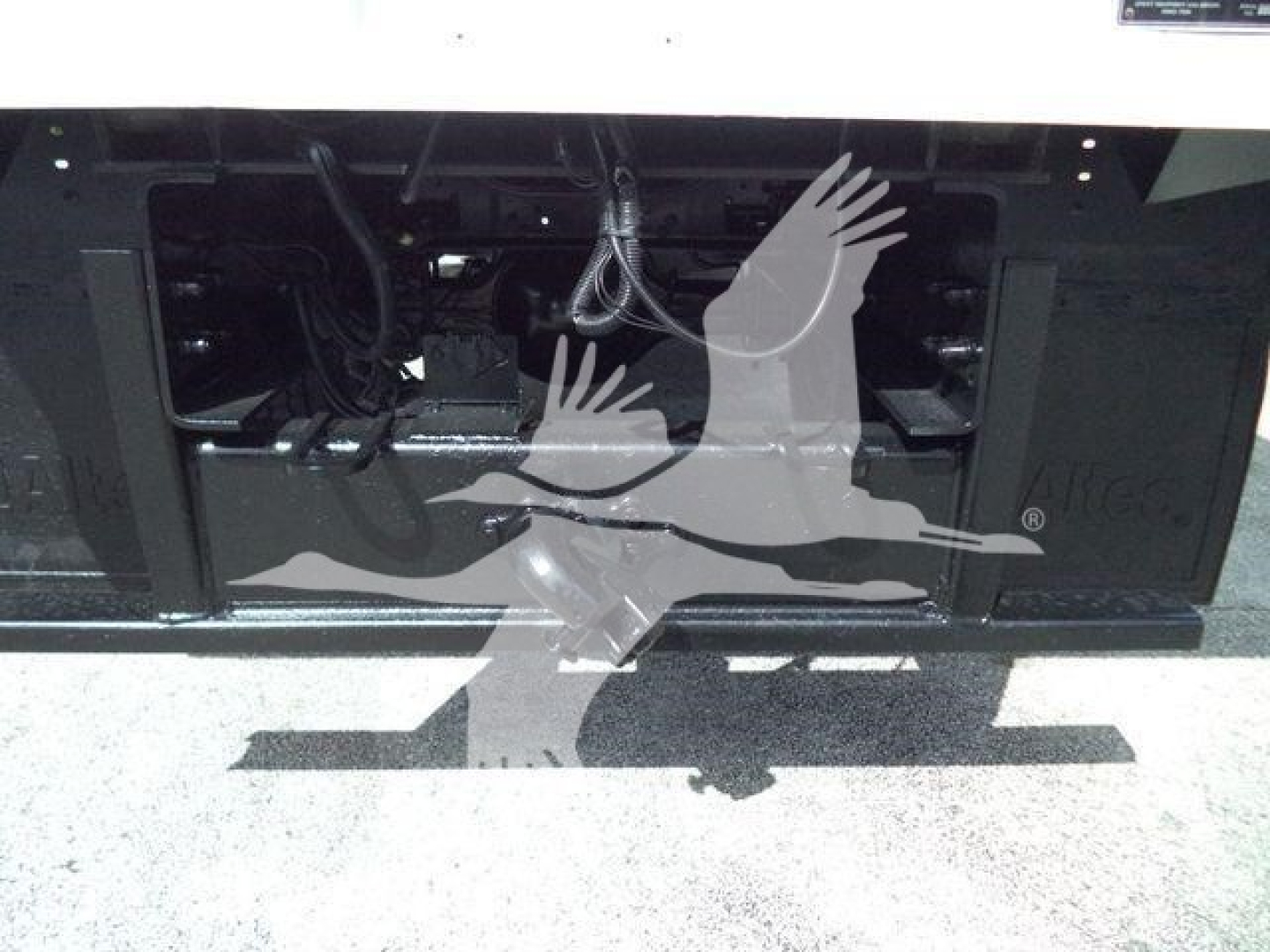 Ford F750 bucket truck front chassis view showing engine bay with various wires and components exposed.