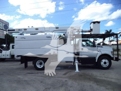 Ford F-750 bucket truck side view showing utility body with boom, stabilizing legs deployed, cab in front, white paint, black wheel wells.