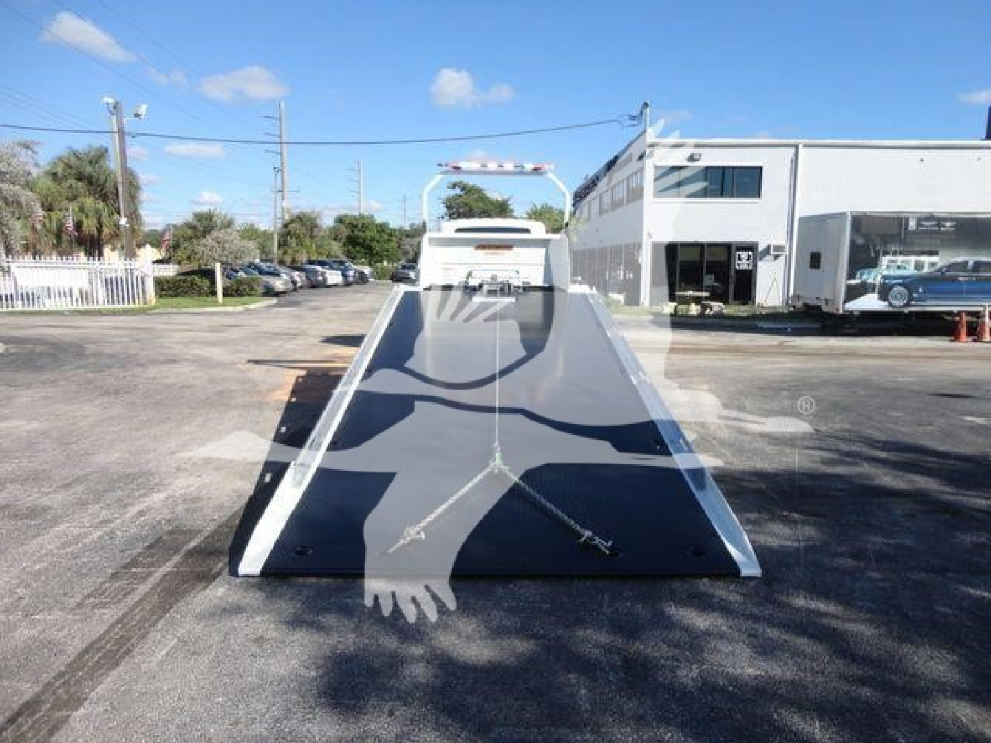 Truck bed/incline ramp of a 2027 International MV, with a long flatbed and loading ramp, seen in a dealership lot.