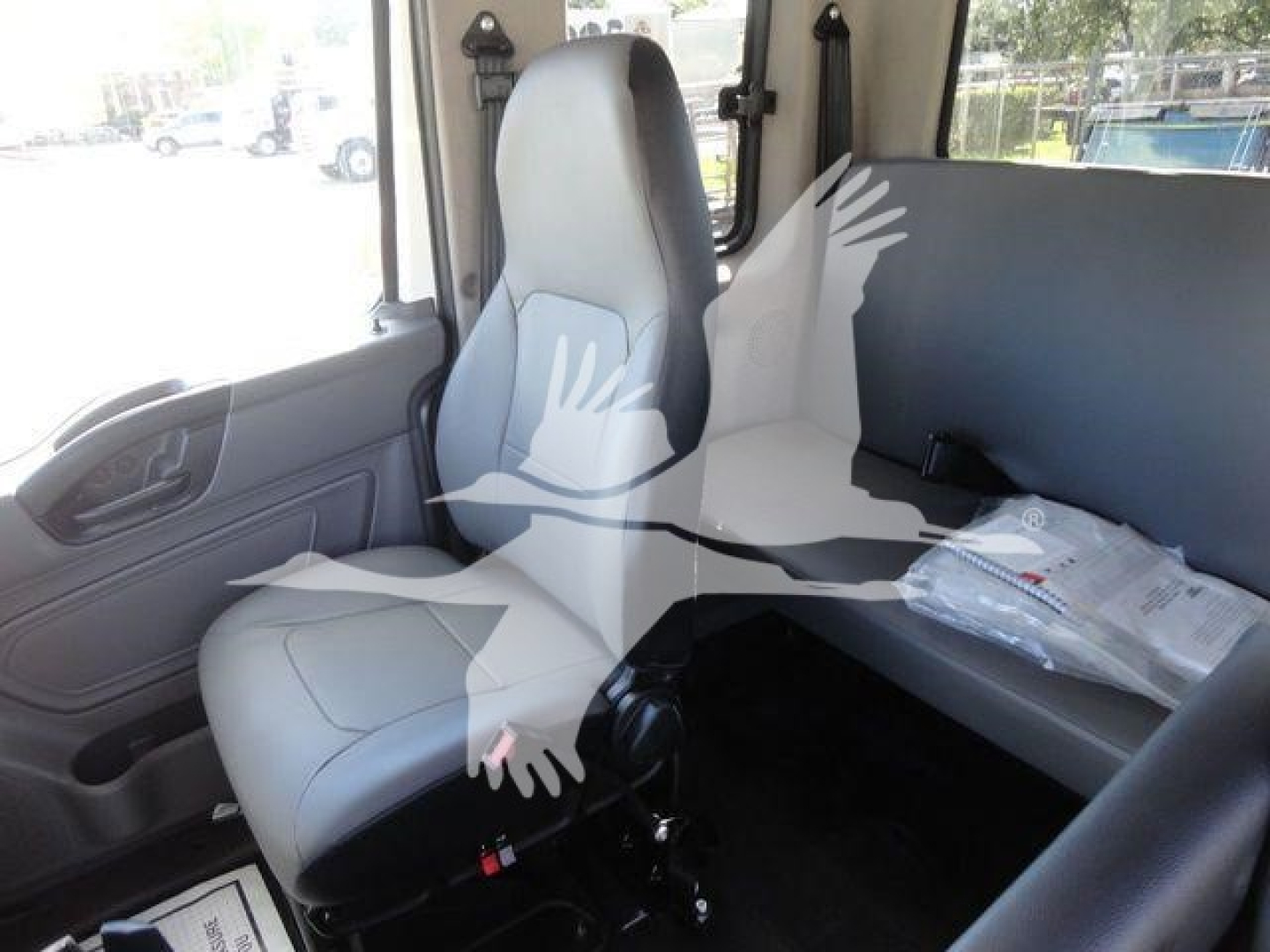 Interior cab of new 2027 International MV rollback truck showing grey seats and side door with window.