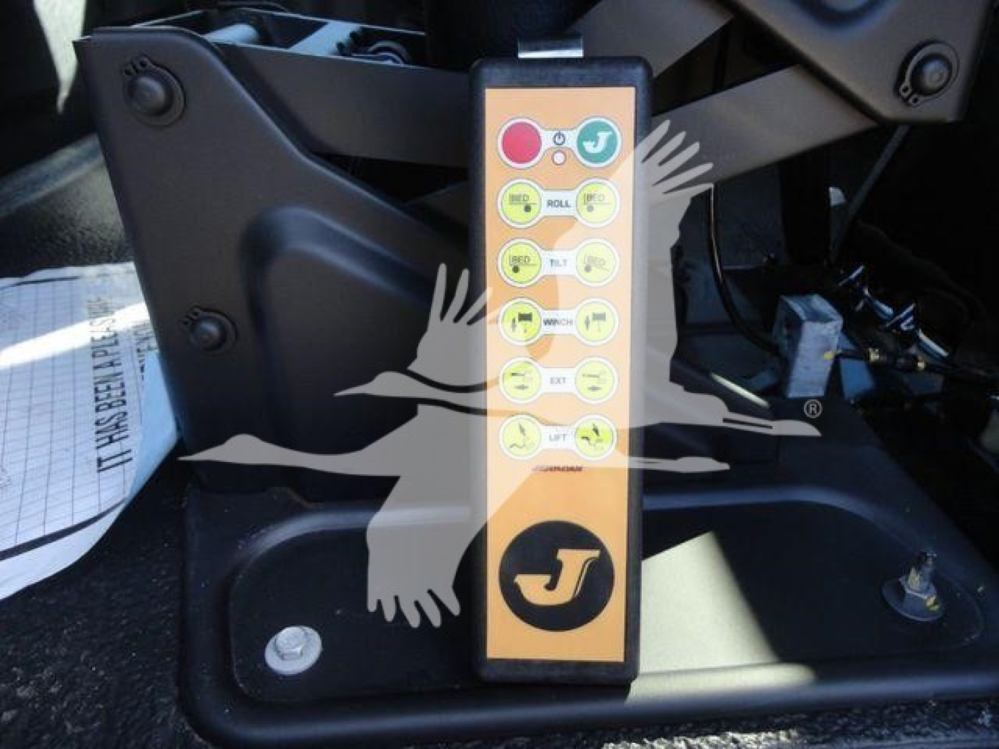 Control panel with multiple labeled buttons on a vertical yellow strip mounted near a truck hitch area.