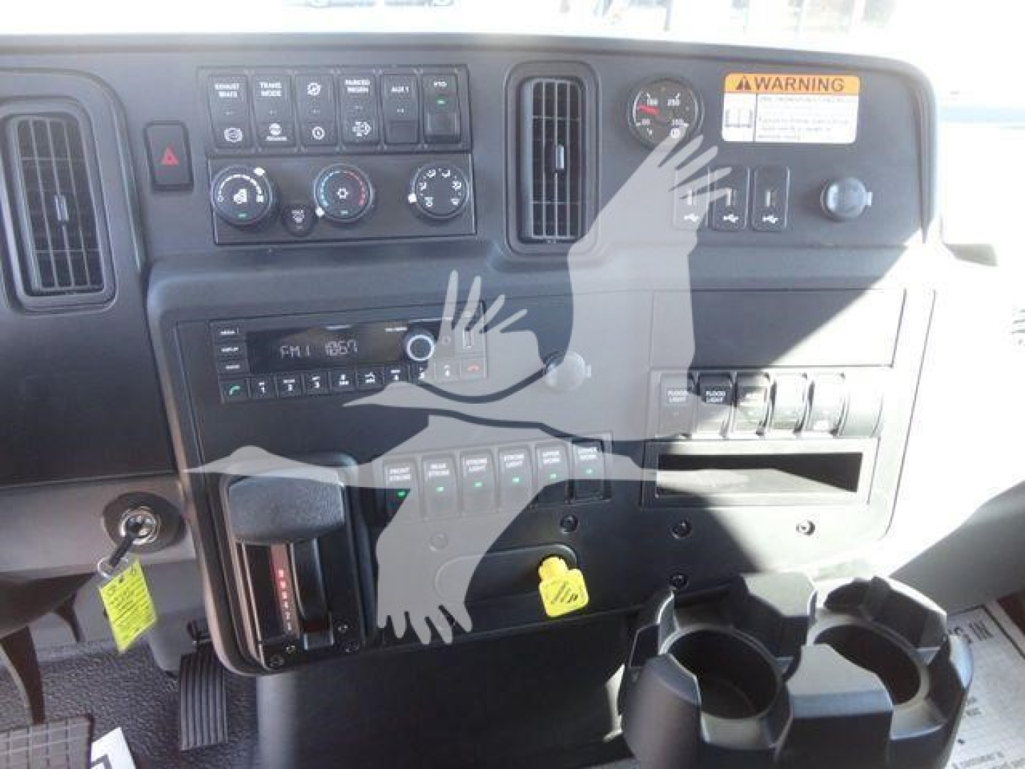 Dashboard and center console of a new 2027 International MV truck showing switches, gauges, and ignition area.