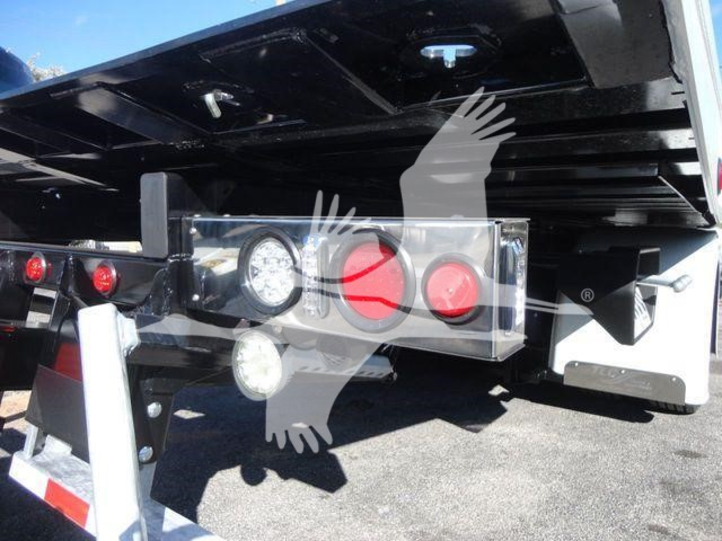 Back of a new 2027 International MV rollback truck showing rear lights, bumper, and hydraulic components with a logo watermark overlaid.
