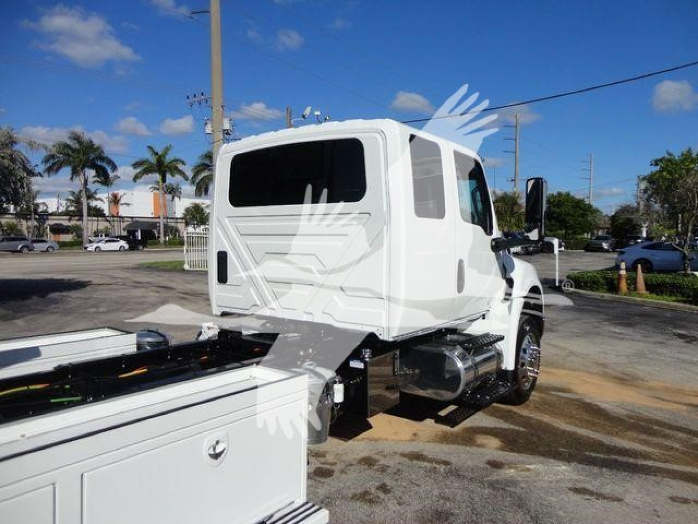 White International MV truck cab rear-side view, with chassis and storage compartments, showing windows and fuel tank area.