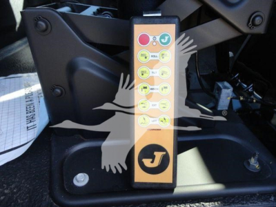 Control panel with multiple labeled buttons on a vertical yellow strip mounted near a truck hitch area.