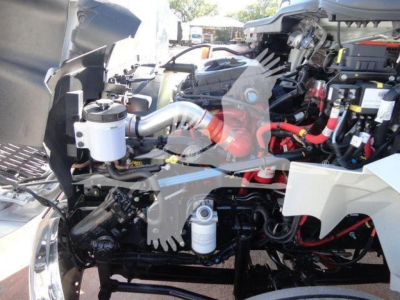 Truck engine bay with multiple hoses and components visible in a MV model International truck.