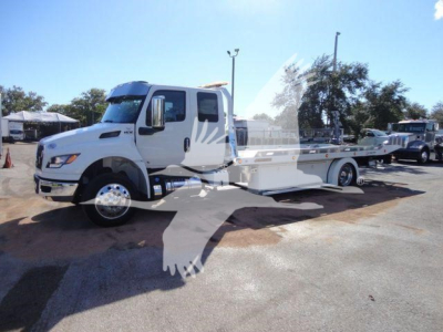International MV rollback truck with flatbed in-service showing white cab and chassis side.
