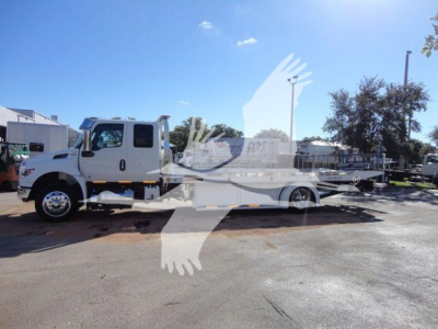 International MV rollback tow truck side view showing cab and flatbed.