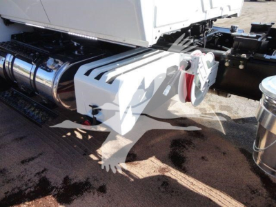 Truck rear undercarriage showing polished chrome fuel tanks and white chassis with hitch and suspension components.