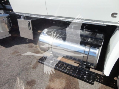 Truck fuel tank and side components visible under a white cab, with a chrome cylindrical fuel tank and steps.
