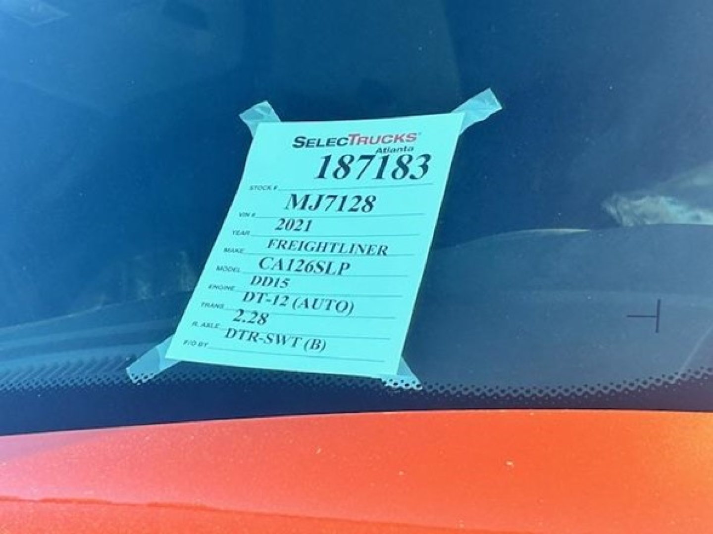 Tag on dashboard with details: 187183 stock, 2021, Freightliner Cascadia, DD15, DT-12 (AUTO), 2.28, DTR-SWT(B)
