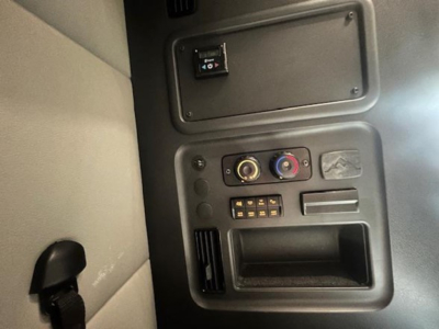 Freightliner Cascadia interior panel showing climate controls and storage pocket near dashboard.
