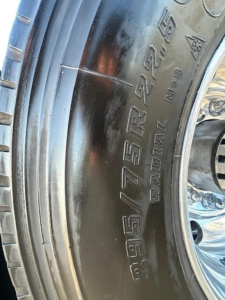 Tire sidewall with size markings 275/? 750? visible on Freightliner Cascadia wheel in a sleeper truck image.