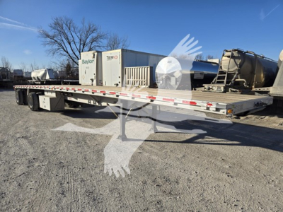 Flatbed trailer showing long low deck with multiple axles and storage boxes. VIN 1RNF48A24FR032383 visible?
