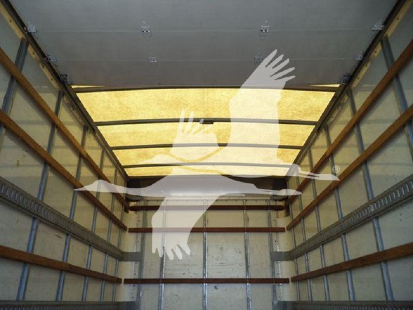 Isuzu NPR HD truck box interior showing empty cargo area with side rails and overhead door.