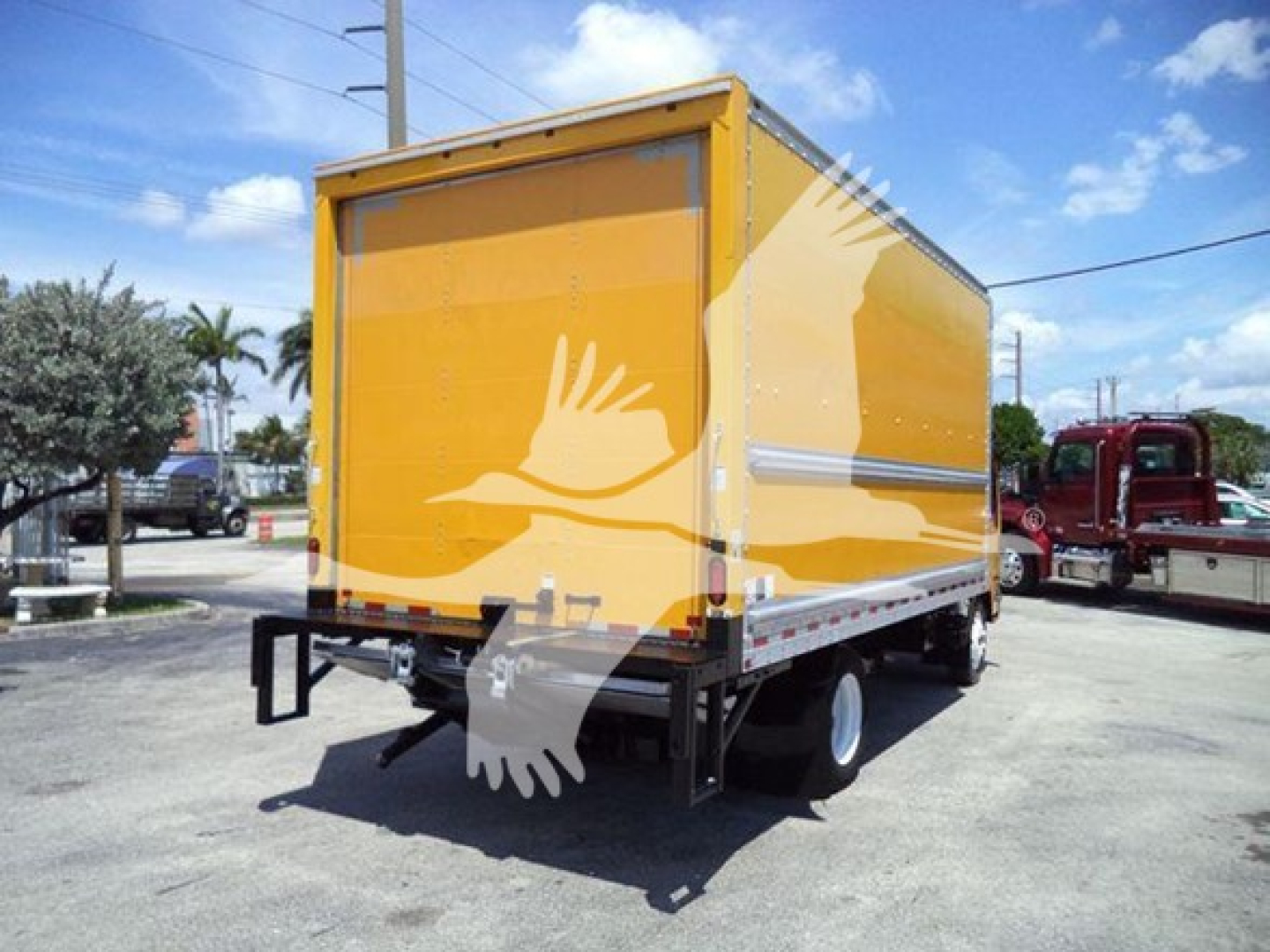 Isuzu NPR HD box truck showing yellow cargo box and rear bumper with no license plate visible.