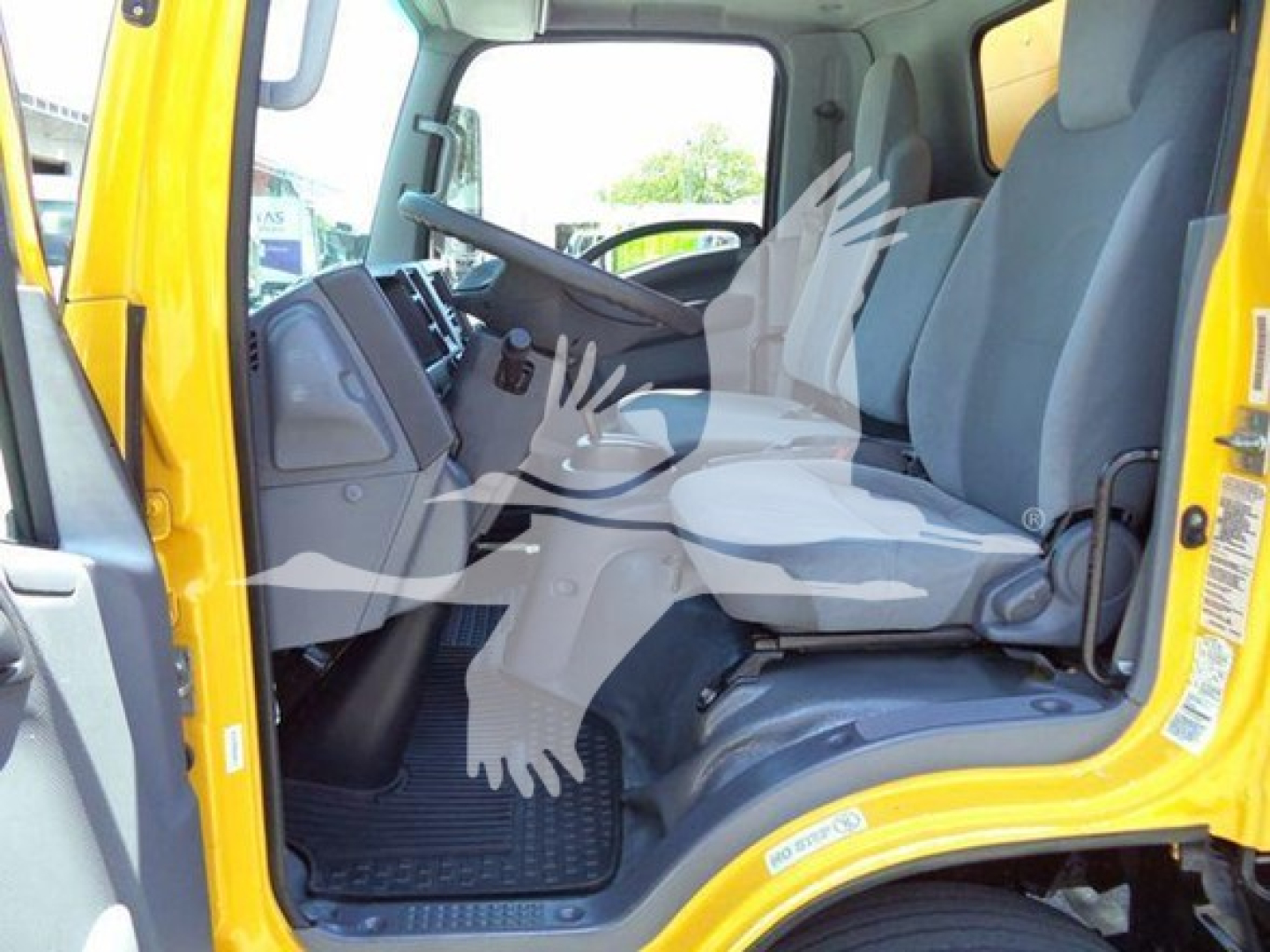 Isuzu NPR HD truck cab interior showing driver's seat and dashboard with steering wheel and pedals.