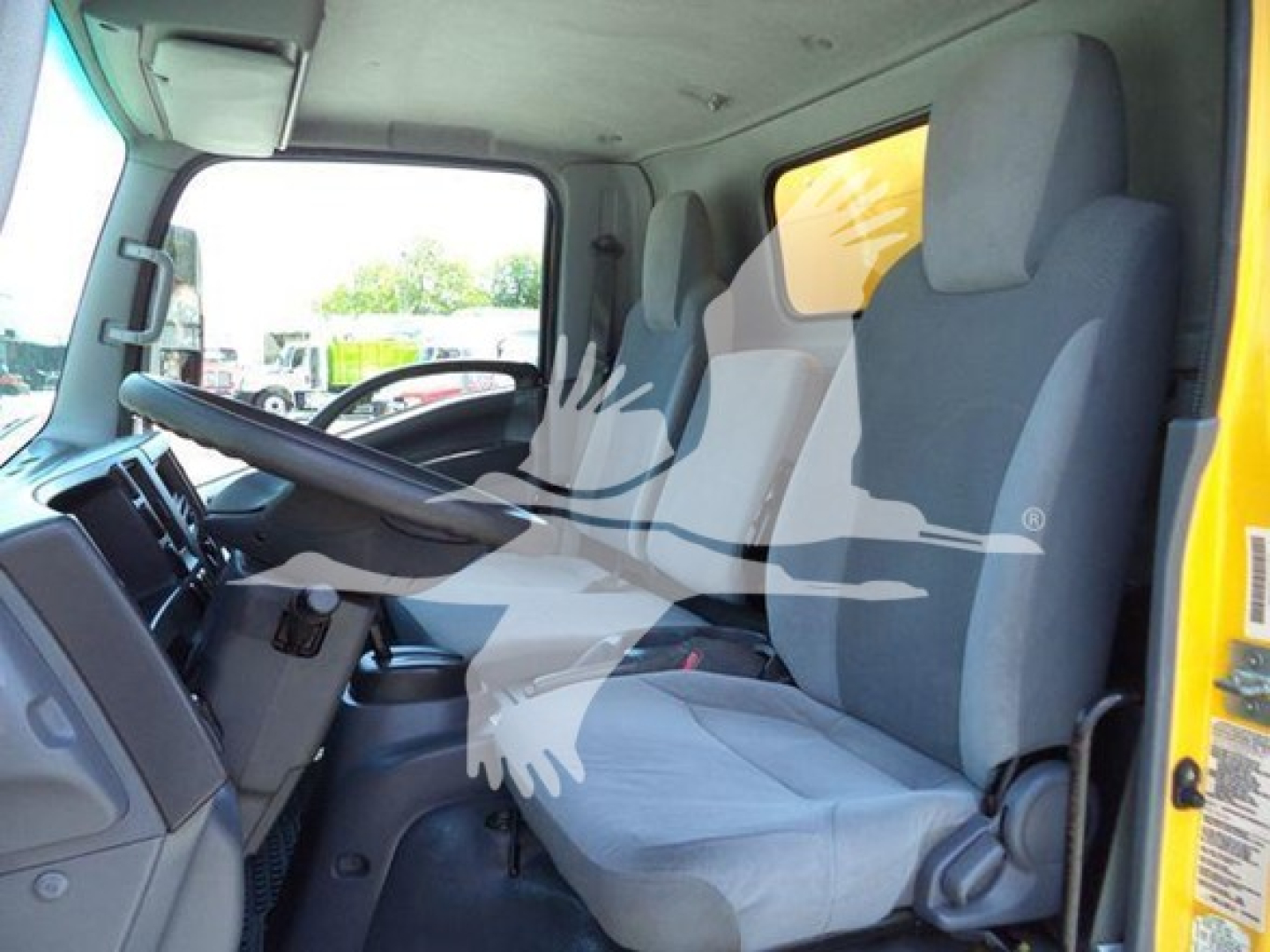 Isuzu NPR HD cargo truck cab interior showing front seats and dashboard with steering wheel