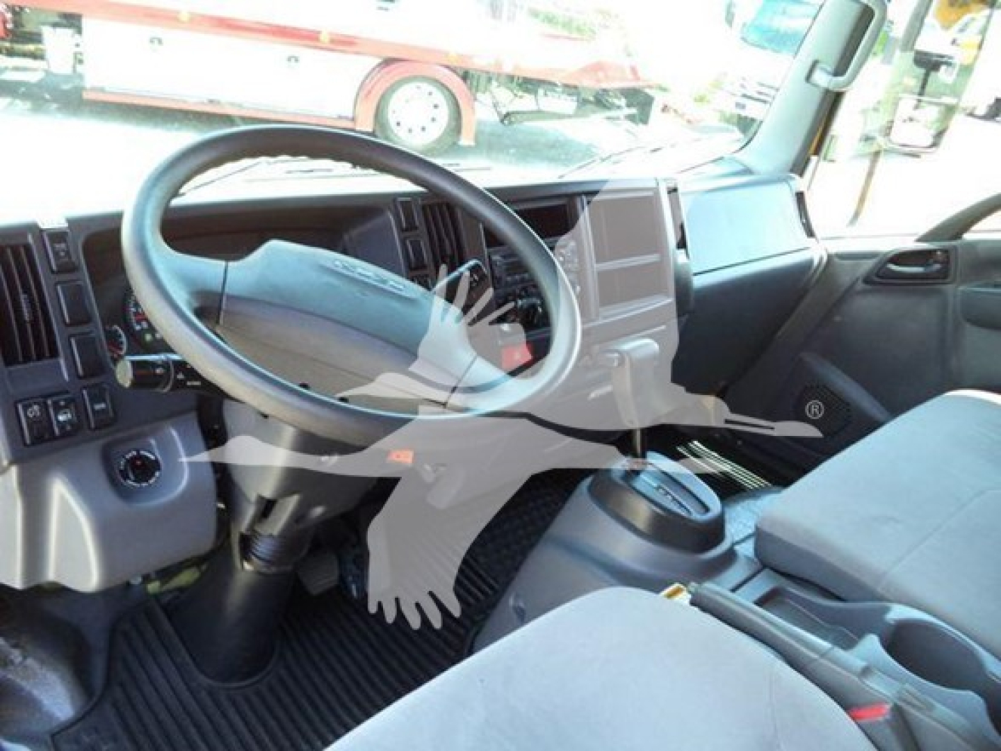 Isuzu NPR-HD interior view showing steering wheel, dashboard, center console, and driver seat area.