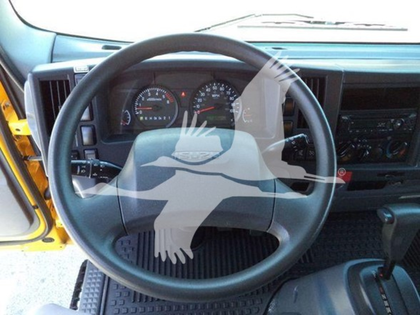 Isuzu NPR-HD truck interior showing steering wheel and dashboard gauges.