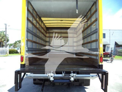 Isuzu NPR HD box truck cargo area with open rear ramp and interior wooden side walls.