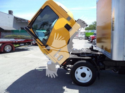 Isuzu NPR HD box truck cab tilted upward showing front wheel and yellow cab with side mirrors.