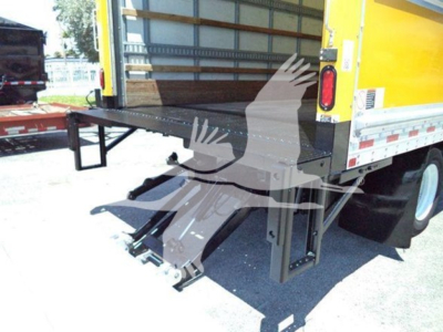 Isuzu NPR HD box truck rear with liftgate extended; visible features include a yellow cargo box and black ramp/loader mechanism.