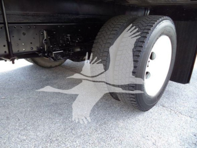 Isuzu NPR-HD truck undercarriage showing front wheel and suspension with tire tread; presence of chassis components and frame