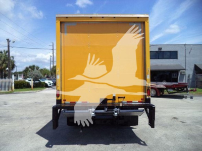 Isuzu NPR HD box truck rear view showing yellow cargo box and rear bumper with hitch, no plate visible.