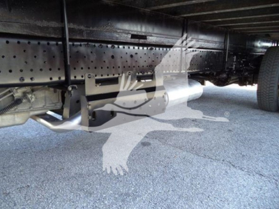 Isuzu NPR HD truck chassis underside showing exhaust pipe and frame rail with bolts and wheel nearby.