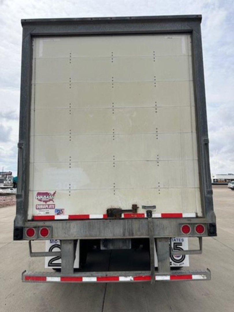 Wabash van trailer rear view showing vertical ribs, rear bumper, taillights, and bumper guards.
