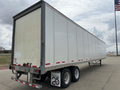Trailer rear and side view showing a Wabash van trailer with dual rear axles and white exterior panels.