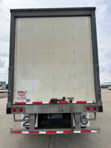 Wabash van trailer rear view showing vertical ribs, rear bumper, taillights, and bumper guards.