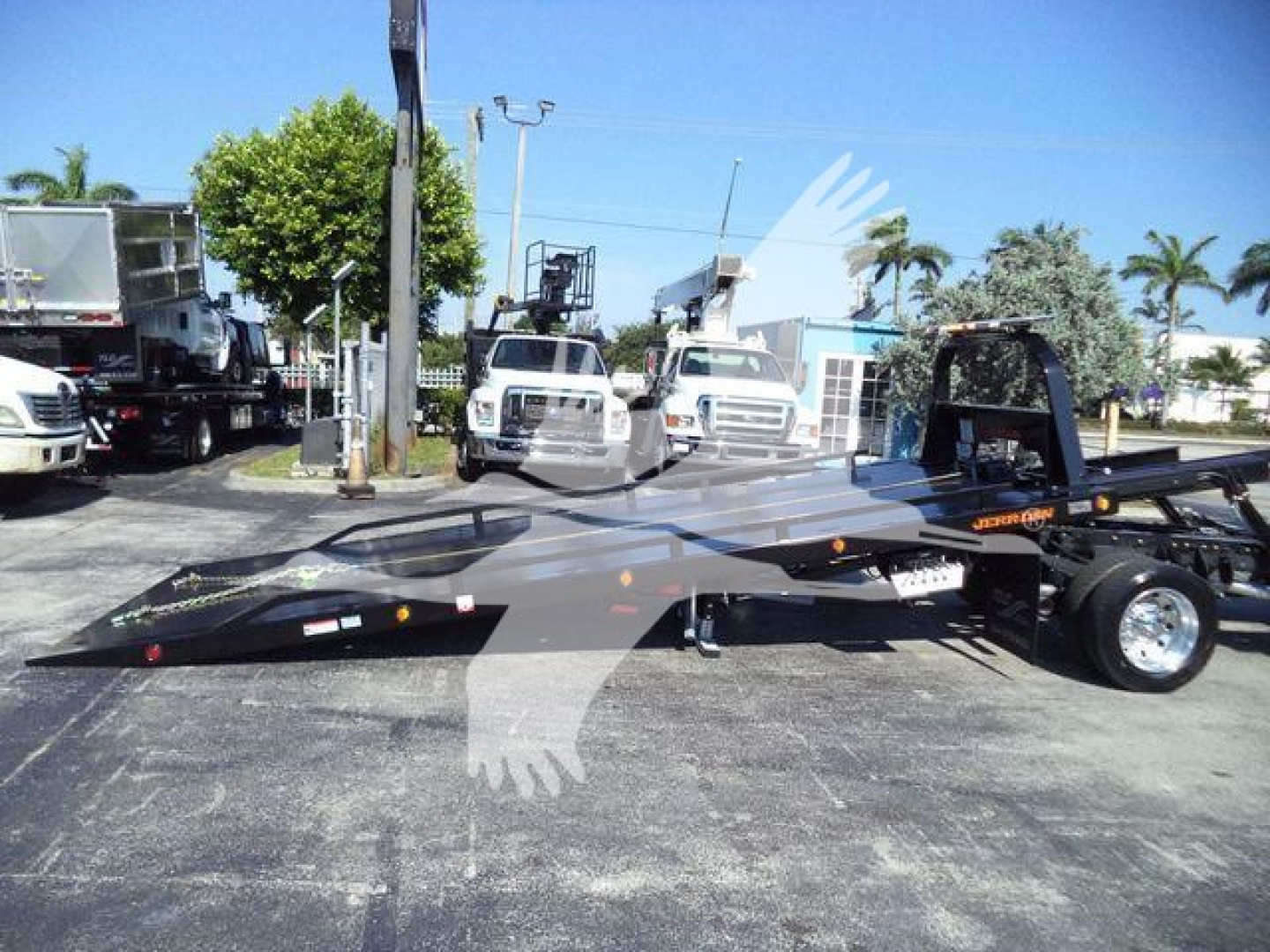 2024 Ram 5500 SLT rollback tow truck with flatbed and wheel-lift, side view showing roll-back bed and dual rear wheels.