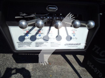 Truck rollback equipment panel with five control levers and labels showing towing options and operating instructions