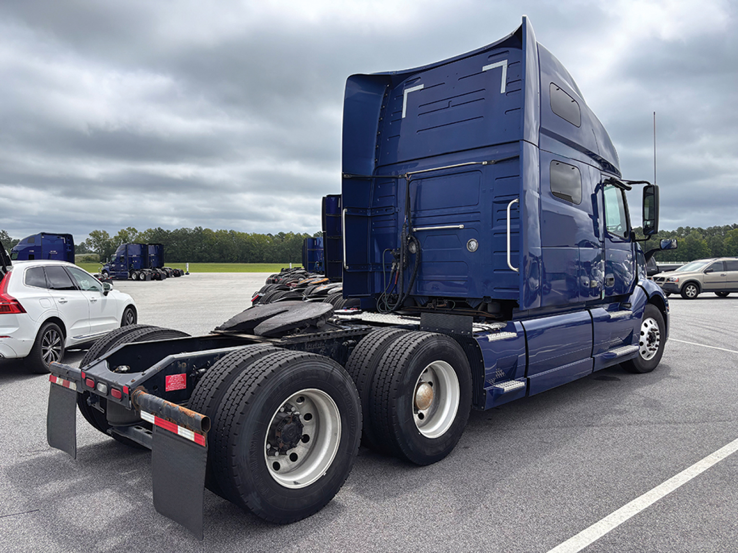 Volvo VNL 760 tractor in blue, rear view showing fifth wheel, dual rear axles, and dual tires; cab with sleeper, side mirrors, and aerodynamic fairings.