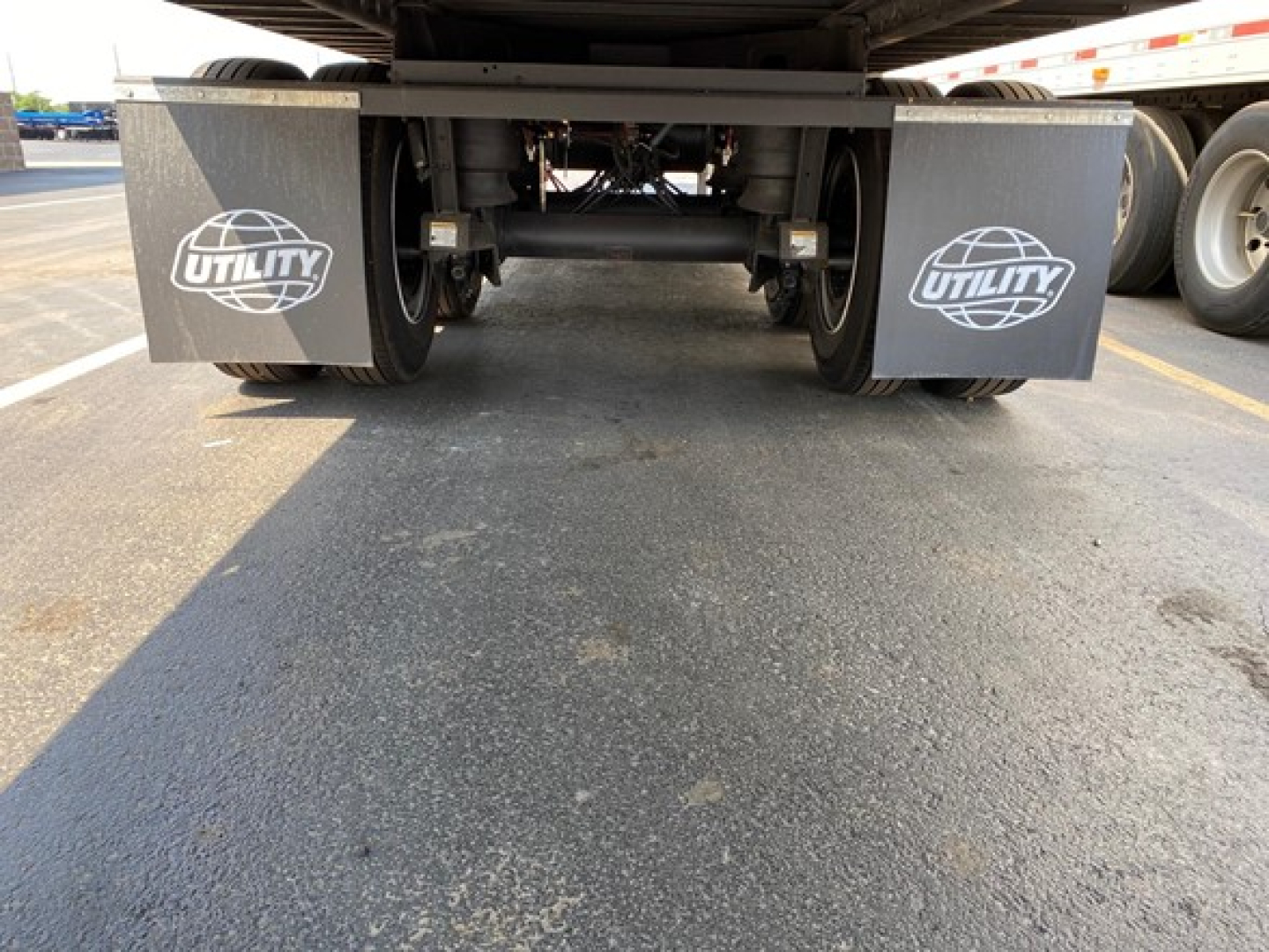 Trailer rear view showing dual mudflaps with Utility logo under truck chassis.